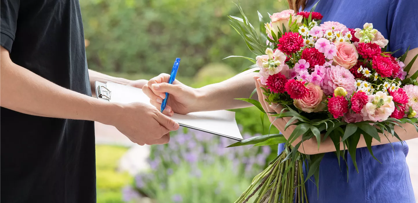 Lieferservice - Frau erhält Blumenpräsent